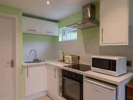 A kitchen with a sink, oven, microwave, and countertops at Cherry Pip in Charmouth