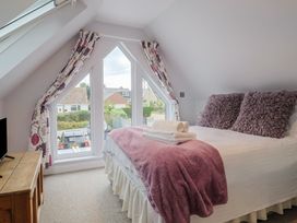 A bedroom with a bed and a television at Cherry Pip in Charmouth
