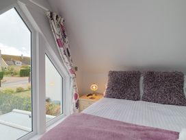 A bedroom with a bed and pillows at Cherry Pip in Charmouth