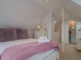 A bedroom with a bed and dresser at Cherry Pip in Charmouth
