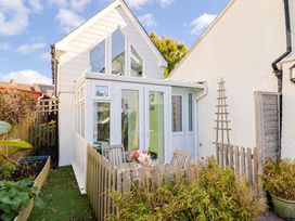 A conservatory with a table and chairs at Cherry Pip in Charmouth
