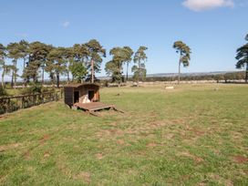 A dog house in a field with trees at Cowshed Cottage East Knapton near Rillington