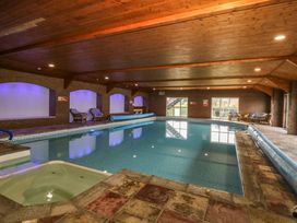 An indoor pool area with a swimming pool and hot tub at Cowshed Cottage East Knapton near Rillington