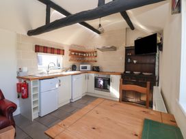 A kitchen with appliances and wooden furnishings at Cowshed Cottage East Knapton near Rillington