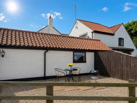 An outdoor area with a table and chairs at Cowshed Cottage in East Knapton near Rillington