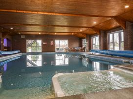 An indoor pool area with seating and pool cover at East Cottage in East Knapton near Rillington