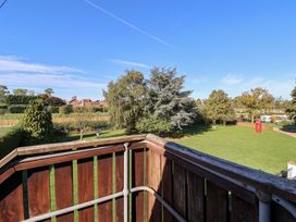 A balcony view overlooking trees and grass at East Cottage in East Knapton near Rillington