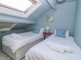 A bedroom with two beds and a bedside table at 3 Marinas side Malton
