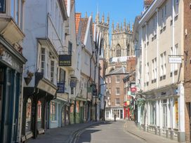 A street view with shops and a cathedral in the background at 3 Marinas side, Malton