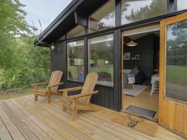 An outdoor area with wooden chairs on the deck at Blue Pine Lodge in Dornoch