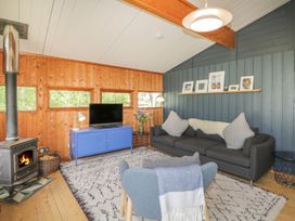 A living room with a sofa and television at Blue Pine Lodge in Dornoch