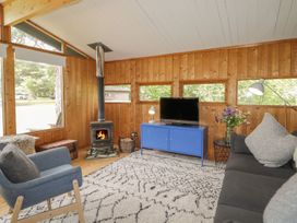 A living room with a stove and television at Blue Pine Lodge in Dornoch