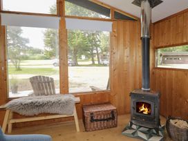 A snug with a wood stove and wooden bench at Blue Pine Lodge in Dornoch