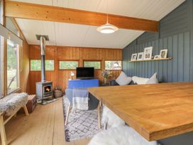 A snug with a television and stove at Blue Pine Lodge in Dornoch