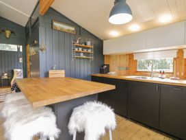 A kitchen with a bar countertop and stools at Blue Pine Lodge in Dornoch