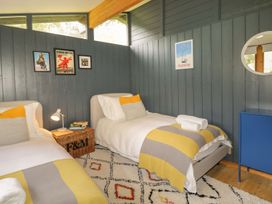 A bedroom with two beds and a nightstand at Blue Pine Lodge in Dornoch
