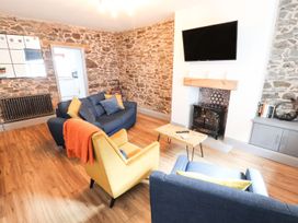 A living room with a sofa and an armchair at 8 Watkin Street Conwy