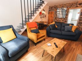 A living room with a sofa and chairs at 8 Watkin Street in Conwy