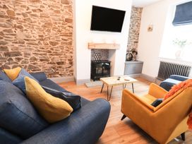 A living room with a sofa and armchair at 8 Watkin Street in Conwy