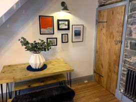 A hallway featuring a table with a vase and wall art at 8 Watkin Street, Conwy