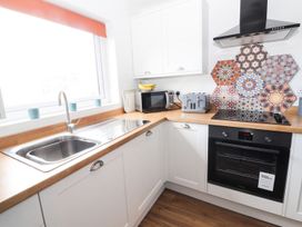 A kitchen with a sink, microwave, toaster, and oven at 8 Watkin Street Conwy