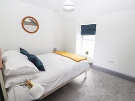 A bedroom with a bed and a mirror at 8 Watkin Street in Conwy