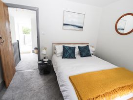 A bedroom with a bed, table lamp, and mirror at 8 Watkin Street in Conwy