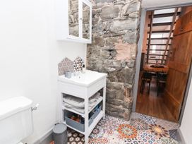 A bathroom with a sink, toilet, and storage unit at 8 Watkin Street, Conwy