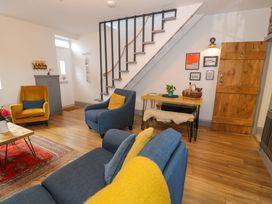A living room with a sofa and armchair at 8 Watkin Street in Conwy