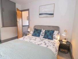 A bedroom with a bed, bedside table and lamps at 8 Watkin Street in Conwy
