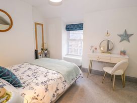 A bedroom with a bed and a desk with a mirror at 8 Watkin Street Conwy