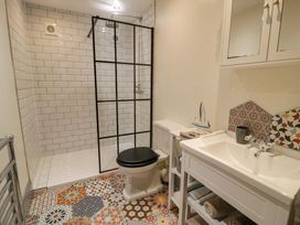 A bathroom with a shower, toilet and wash basin at 8 Watkin Street, Conwy