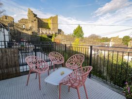 An outdoor area with chairs and a table overlooking castle ruins at 8 Watkin Street Conwy