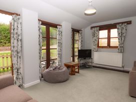 A living room with a sofa and a TV at The Milking Shippon at Thorne Langtree near Great Torrington