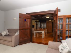 A living room with a sofa and a door leading to the dining area at The Milking Shippon at Thorne Langtree near Great Torrington