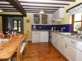 A kitchen with cabinets, a table, and appliances at The Milking Shippon at Thorne near Great Torrington