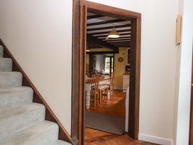 A hallway leading to a dining area with wooden furniture at The Milking Shippon at Thorne near Great Torrington