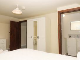 A bedroom with a wardrobe and sink at The Milking Shippon at Thorne near Great Torrington