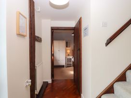 A hallway with stairs and a door leading to another room at The Milking Shippon at Thorne, Langtree near Great Torrington