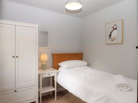 A bedroom with a single bed and a wardrobe at The Milking Shippon at Thorne, Langtree near Great Torrington