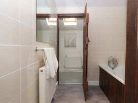 A bathroom with a bathtub and a towel rack at The Milking Shippon at Thorne Langtree near Great Torrington