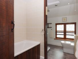 A bathroom with a bathtub and toilet at The Milking Shippon at Thorne near Great Torrington