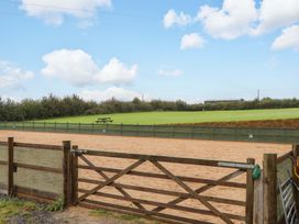 An outdoor horse arena with a picnic table at The Milking Shippon at Thorne Langtree near Great Torrington
