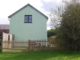 A house with a fence and garden furniture at The Milking Shippon at Thorne, Langtree near Great Torrington
