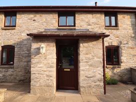 An entrance with a stone wall and door at Ty Cerrig apartment