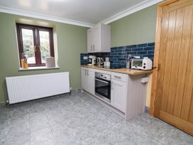 A kitchen with cabinets and appliances at Ty Cerrig apartment