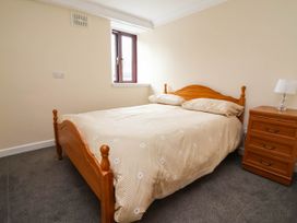 A bedroom with a bed and nightstand at Ty Cerrig apartment 