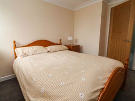 A bedroom with a bed and nightstand at Ty Cerrig apartment