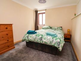 A bedroom with a bed and dresser at Ty Cerrig apartment