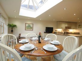 A dining room with a table set for dinner at The Coach House in Burford